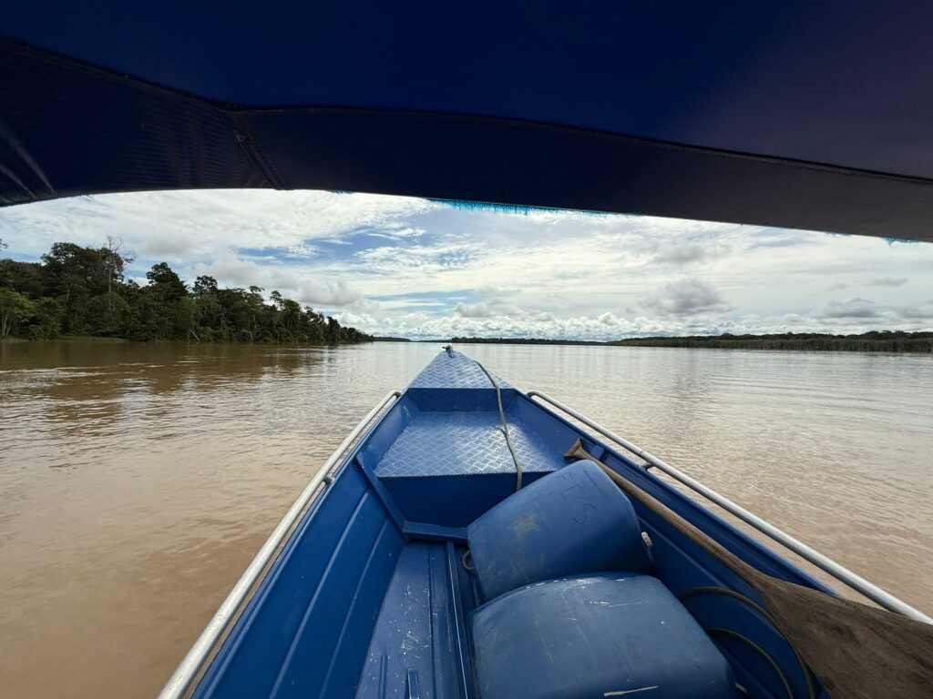 View from the bow of a boat travelling along a wide Amazon river